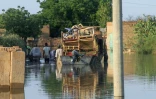 Des habitants transportent leurs effets personnels lors d'inondations dans le village de Wad Ramli au nord de Khartoum au Soudan, le 1er octobre 2025