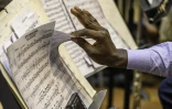 Un musicien de l'orchestre kimbanguiste de Kinshasa tourne les pages d'une partition lors d'une répétition, le 16 octobre 2024 en RDC
