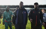 Le footballeur français Paul Pogba (c) et son frère Mathias Pogba (g) marchent sur le terrain avant un match de football entre All Star France et la Guinée au stade de la Vallée du Cher à Tours, le 29 décembre 2019