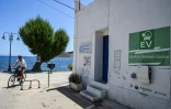 Un cycliste passe devant une station de recharge solaire pour véhicules électriques, sur l'île de Tilos, en Grèce, le 22 juin 2021