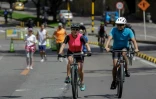 Des cyclistes et joggeurs sur une piste cyclable lors de la journée hebdomadaire sans voiture à Bogota, le 8 décembre 2024 en Colombie