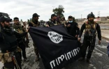 Des soldats irakiens avec un drapeau du groupe EI le 2 novembre 2016 à Gogjali