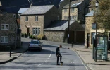 Un jeune homme joue au football dans une rue tranquille du village d'Eyam, dans le Nord de l'Angleterre, le 23 mars 2020.