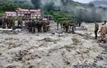 Cette photographie, diffusée le 6 août 2025 par l'armée indienne, montre des agents de sécurité et de secours soulevant des pierres et des débris pour construire un passage, au lendemain d'une violente averse qui a provoqué une coulée de boue massive et des crues soudaines dans l'État indien de l'Uttarakhand
