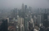 Les tours Petronas et des immeubles commerciaux enveloppés par la brume à Kuala Lumpur, le 13 octobre 2026 en Malaisie