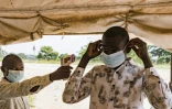 Un agent sanitaire à la frontière du poste de Busunga, entre l'Ouganda et la République démocratique du Congo, prend la température d'un voyageur à l'aide d'un thermomètre infrarouge sans contact à Bundibugyo, le 18 mai 2026. 
