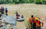 Des membres de la police armée recherchent des survivants dans la rivière Trishuli après un glissement de terrain qui a emporté deux bus, le 13 juillet 2024 à Simaltar, au Népal
