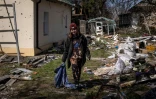 Une Ukrainienne dans le jardin d'une maison dévastée à Bohdanivka, au nord-est de Kiev, le 14 avril 2022