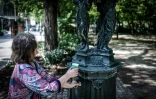 Une femme remplit un gobelet d'eau à une fontaine publique du quartier Montparnasse à Paris, le 25 mai 2026, alors que Météo-France a placé la capitale en alerte jaune face à une vague de chaleur exceptionnellement précoce