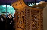 Le président Emmanuel Macron admire un trône du du royaume d'Abomey exposé au musée du quai Branly, le 27 octobre 2021 à Paris, avant d'être restitué avec d'autres oeuvres au Bénin