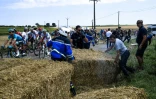 Des gendarmes libèrent la chaussée brièvement bloquée par les agriculteurs à coup de meules de foin durant la 14e étape du Tour, le 24 juillet 2018