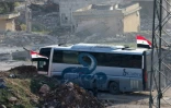 Un bus au passage de Ramoussa, sous contrôle des forces gouvernementales syriennes dans le sud d'Alep, le 18 décembre 2016 dans le cadre d'une opération d'évacuation de civils et de soldats rebelles