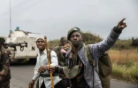 Des miliciens Wazalendo (Patriotes en swahili), près d'un véhicule blindé du contingent uruguayen de la Monusco le long de la route menant à l'entrée de Sake, à 25 km au nord-ouest de Goma, le 23 janvier 2025 en RDC