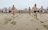 Des hollandais courent vers la mer du Nord, lors du traditionnel bain du Nouvel An à Scheveningen