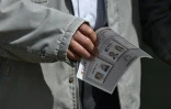 Un electeur tient un bulletin de vote lors du deuxième tour de la présidentielle colombienne à Bogota, le 17 juin 2018