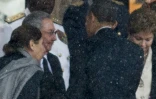 Le président américain Barack Obama serre la main du président cubain Raul Castro lors des obsèques de Nelson Mandela, dans le stade de Soweto, le 10 décembre 2013 à Johannesburg, en Afrique du Sud