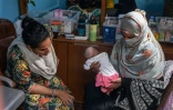 La sage-femme Neha Mankani (g) examine un nourrison dans sa clinique de l'île de Baba, le 6 juin 2024 au Pakistan