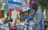 Un peintre des rues réalise des portraits du pape François à Nairobi le 20 novembre 2015
