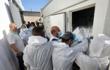 Des employés de la morgue déchargent les corps de Palestiniens qui étaient détenus par Israël, après leur transport par des véhicules du Croissant-Rouge et des camions frigorifiques, à l’hôpital Nasser de Khan Younès, dans le sud de la bande de Gaza, le 15 octobre 2025