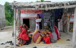 Des travailleuses sociales (d) enseignent à des mères comment préparer des repas nutritifs pour leurs enfants lors d'un programme de nutrition de l'Unicef au village de Fateh Muhammad Soomro, dans la province du Sindh, le 29 juillet 2025 au Pakistan