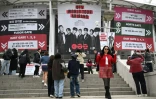 Des fans posent pour des photos devant une grande banderole à l'effigie du boys band de K-pop BTS, sur les marches menant au stade où le groupe se produira, à Goyang, le 9 avril 2026