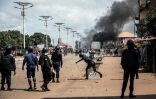 Un policier lance une pierre sur des manifestants à Conakry, le 21 octobre 2020 en Guinée