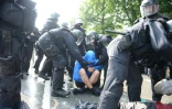 Des policiers tentent de faire bouger un manifestant anti-G20 assis sur la chaussée, le 7 juillet 2017à Hambourg
