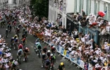 Le maillot jaune Tadej Pogacar roule avec le peloton dans la montée de la rue Lepic sur la Butte Montmartre, en passant devant le moulin de la Galette, lors de la 21e et dernière étape du Tour de France le 27 juillet 2025