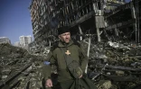 Un prêtre militaire parmi les débris du centre commercial Rettroville, à Kiev le 21 mars 2022