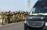 Des soldats israéliens saluent l'arrivée du convoi funéraire de la famille Bibas, au kibboutz Nir Oz, dans le sud d'Israël, le 26 février 2025