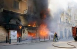 Des pompiers s'emploient à éteindre le feu dans une banque provoqué par des manifestants à Tripoli, dans le nord du Liban, le 28 avril 2020
