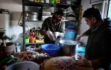 Le chef cuisinier syrien Talal Rankoussi (c) prépare un repas pour les réfugiés du camp de Ritsona, au nord d'Athènes, le 21 décembre 2016 en Grèce