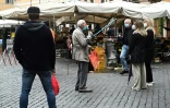 Discussion sur un marché du centre de Rome entre plusieurs personnes qui respectent les distances de sécurité, le 21 avril 2020
