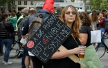 Une femme porte une pancarte hostile aux entreprises pharmaceutiques alors qu'elle participe à un rassemblement place de la République à Paris le 14 juillet 2021 pour protester contre une décision gouvernementale d'imposer des tests Covid-19 aux personnes non vaccinées qui veulent manger dans les restaurants ou prendre longtemps- voyages à distance, alors que le pays cherche à éviter une augmentation des cas Delta plus contagieux. 
