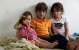 Trois des enfants du Libanais Moustafa al-Sayyed qui a fui son village avec sa famille, assis dans une salle de classe d'une école à Tyr dans le sud du Liban, transformée en refuge pour les déplacés, le 19 octobre 2023