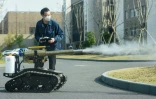 Un employé commande un robot pour désinfecter des rues à Hangzhou dans l'est de la Chine, le 25 février 2020