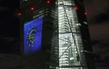 La tour du bâtiment principal de la Banque centrale européenne (BCE) photographiée de nuit montrant le symbole lumineux de l'euro à Francfort-sur-le-Main, dans l'ouest de l'Allemagne, le 30 décembre 2021, lors d'un aperçu de l'illumination de l'anniversaire de l'euro liquide