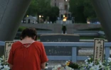 Une femme prie dans le parc du Mémorial de la Paix, à Hiroshima, le 6 août 2017