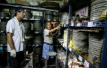 Le collectionneur Wang Chin-ting (D) montre des bobines de vieux films taïwanais à un membre de l'Institut taïwanais du cinéma et de l'audiovisuel (TFAI), le 29 mai 2026 à Changhua, dans la province de Taïwan