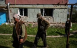 Des personnes s'apprêtent à recevoir de l'aide humanitaire à Vilkhivka, près de Kharkiv, est de l'Ukraine, le 14 mai 2022
