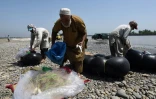 Des pêcheurs pakistanais rangent leur filet le 18 août 2016, après leurs prises dans la rivière Kaboul, au village Hajji Zai dans le nord ouest du Pakistan