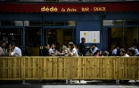 Des personnes déjeunent à la terrasse élargie d'un bar à Paris, le 23 juillet 2020