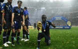 Le Français N'Golo Kanté (à droite) pose avec le trophée de la Coupe du Monde de football, le 15 juillet 2018 à Moscou