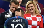 Le président français Emmanuel Macron félicite Kylian Mbappé sous les yeux de la présidente croate Kolinda Grabar-Kitarovic, après la finale du Mondial, le 15 juillet 2018 à Moscou