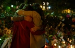 Des gens s'enlacent devant un mémorial en hommage aux victimes de l'attentat du Bataclan, le 20 novembre 2015 à Paris