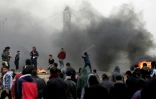 Des manifestants palestiniens lancent des pierres et incendient des pneus lors du premier anniversaire des "Grandes marches du retour", le long de la barrière frontalière entre la bande de Gaza et Israël, le 30 mars 2019 à l'est de Gaza city