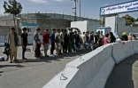 Des Afghans, espérant quitter le pays, font la queue devant l'entrée de l'aéroport de Kaboul, le 29 août 2021