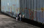 Une famille devant la barrière séparant le Mexique des Etats-Unis, le 16 janvier 2019 à Tijuana