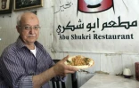 Yasser Taha, patron du restaurant palestinien Abou Choukri, pose avec une assiette de houmous, le 12 septembre 2015 à Jérusalem