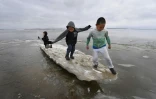 Des enfants jouent sur un morceau de glace près du village eskimau de Yupik, en Alaska (Etats-Unis), le 19 avril 2019